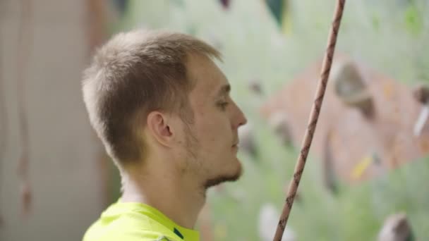 一个登山者准备爬上大厅的墙，用粉笔粉笔和保险在慢动作爬墙的肖像 — 图库视频影像