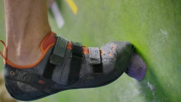 Il giovane arrampicatore sta scalando la palestra di arrampicata Inside. sottile grazioso uomo esercizio a indoor climbing palestra parete — Video Stock