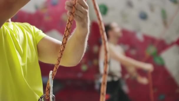 Людина відмовляється від іншого альпініста з мотузкою. Вид зверху на юного атлетичного чоловіка, що відстає і дивиться інший альпініст з мотузкою. Літній час. обладнання для скелелазіння — стокове відео