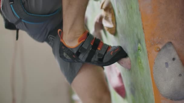 Närbild av fötter skodda i skor för bergsklättring övervinna hinder på klätterväggen — Stockvideo