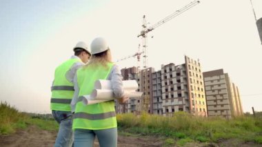 Geri döndü mühendis ve müfettiş şantiye de ofis planları ve teknik çizimler gözden yürüyüş ve tartışma