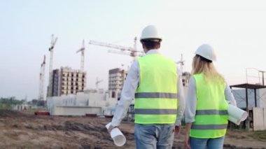 Geri döndü mühendis ve denetleyici şantiye de ofis planları ve teknik çizimler gözden yürüyüş ve tartışma