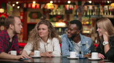 Bir barda otururken ve birlikte kahve içerken bir grup drears bir şaka gülüyor