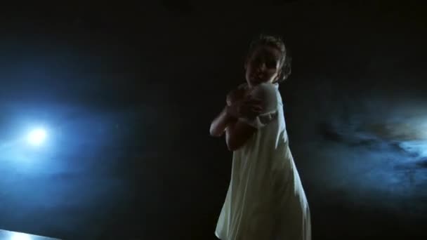 Danseuse moderne dans une robe courte blanche effectue de belles danses dramatiques en plastique, courant à travers la scène, tombant sur le sol et tournant. Lanternes et fumée — Video