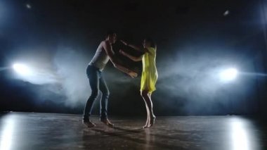 İki dansçı bir erkek ve bir kadın birbirlerine koşmak ve bir erkek ortağı kollarında sarı bir elbise bir kadın yükseltir ve havada en iyi destek performans döner