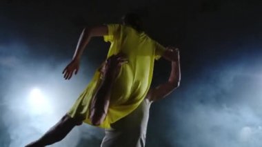 Zoom kamera, bir kadın dansçı ortağı omzuna atlar. Sahnede duman halinde akrobatik dans müzikali. Çağdaş Contemp