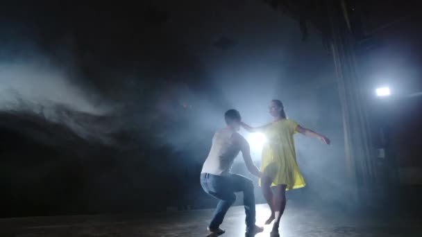 두 댄서 남자와 여자는 서로 실행하고 남성 파트너는 그녀의 팔에 노란색 드레스를 입고 여자를 제기하고 최고 지원을 수행하는 공중에서 회전 — 비디오