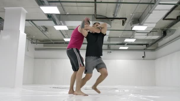 İki güreşçi ağır çekimde performans gösterir. Greko-Romen güreşçiler t-shirt ve palto salonda tren. — Stok video