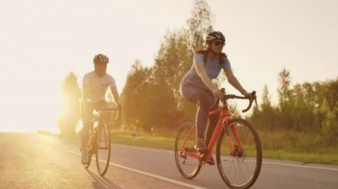Sert Eğitim.Triathlete iki Bisikletçi Eğitim Yol Bisiklet i. Iki Bisikletçi City Park'ta Yol Bisikleti Üzerinde Sürme ve Triatlon.Fit Atlet Yoğun Eğitim iki erkek ve kadın Bisiklet için hazırlanıyor