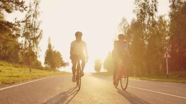 Steadicam disparo de bicicleta de montaña pareja montar en bicicleta sendero al atardecer haciendo alto — Vídeo de stock