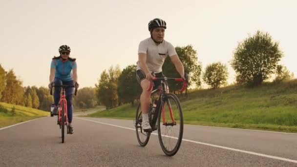 Triathlète deux cyclistes d'entraînement sur vélo de route. deux cycliste chevauchant sur le vélo de route dans le parc de la ville et se préparant pour Triathlon.Fit Entraînement intensif d'athlète deux homme et femme faisant du vélo — Video