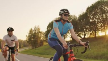 Sert Eğitim.Triathlete iki Bisikletçi Eğitim Yol Bisiklet i. Iki Bisikletçi City Park'ta Yol Bisikleti Üzerinde Sürme ve Triatlon.Fit Atlet Yoğun Eğitim iki erkek ve kadın Bisiklet için hazırlanıyor