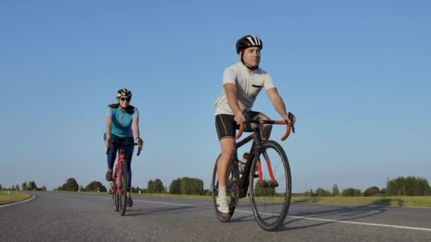 Sert Eğitim.Triathlete iki Bisikletçi Eğitim Yol Bisiklet i. Iki Bisikletçi City Park'ta Yol Bisikleti Üzerinde Sürme ve Triatlon.Fit Atlet Yoğun Eğitim iki erkek ve kadın Bisiklet için hazırlanıyor