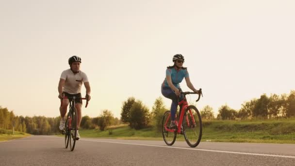 Отслеживающая съемка группы велосипедистов на проселочной дороге. Полностью выпущена для коммерческого использования — стоковое видео