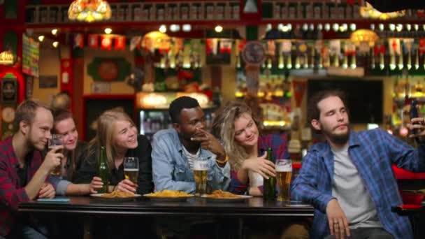W barze lub restauracji Hiszpan człowiek bierze selfie samej siebie i jej najlepszych przyjaciół. Grupa pięknych młodych ludzi w stylowym zakładzie — Wideo stockowe