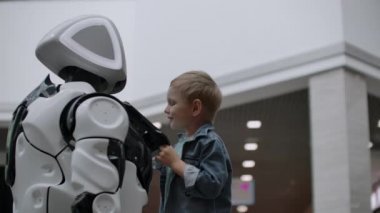 İnsansı robot teknoloji fuarında çocukla konuşuyor. Robotların Sergi Parkı. İnsansı robot ile konuşuyor.
