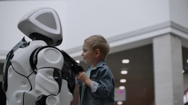 Robot humanoide habla con el niño en la exposición de tecnología. El Parque de Exposiciones de Robots. Robot humanoide habla con . — Vídeo de stock