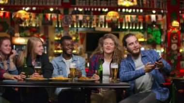 Arkadaşlar barda telefonda fotoğraf çeker, telefonda paylaşılan bir fotoğraf çekerler. Bira ile barda arkadaşlarınızla Parti