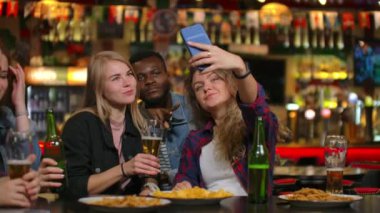 Barda cep telefonuyla selfie çeken bir grup farklı arkadaş