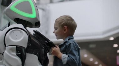 İnsansı robot teknoloji fuarında çocukla konuşuyor. Robotların Sergi Parkı. İnsansı robot ile konuşuyor.