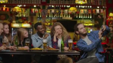 içme ve barda gülen genç arkadaş grubu.
