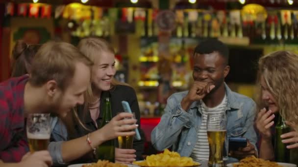 Groep van jonge vrienden drinken en lachen in een bar. — Stockvideo