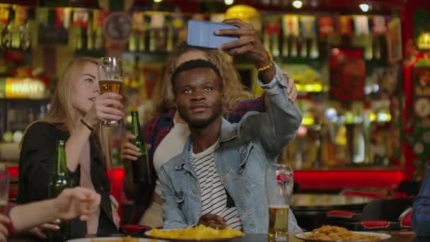 Grupo de jóvenes amigos bebiendo y riendo en un bar . — Vídeos de Stock