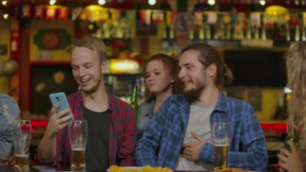 Gruppe junger Freunde trinkt und lacht in einer Bar. — Stockvideo