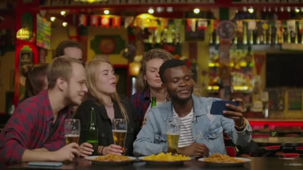 Groep gelukkig multiraciale vrienden maken een toast met bier bij bar of pub — Stockvideo
