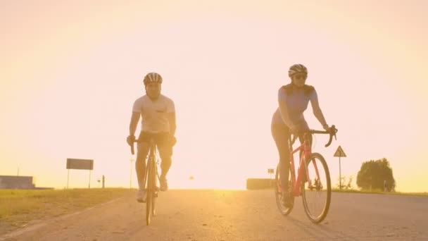 Twee fietsers rijden samen in bergen. Zacht gefocuste handheld schot van twee professionele fietsers van sport team plezier tijdens harde training, sprinten. — Stockvideo