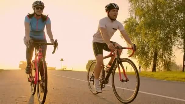 Двое велосипедистов едут вместе в горы. Мягко сфокусированный ручной снимок двух профессиональных велосипедистов из спортивной команды, веселящихся во время тяжелой тренировки, бега . — стоковое видео