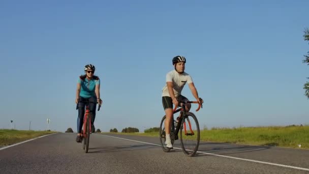 Ciclista equitação na estrada bicicleta traseira View.Cycling homens pedalar bicicleta de estrada no parque da cidade.Tracking tiro de passeios de ciclista na bicicleta de estrada ao pôr-do-sol. . — Vídeo de Stock