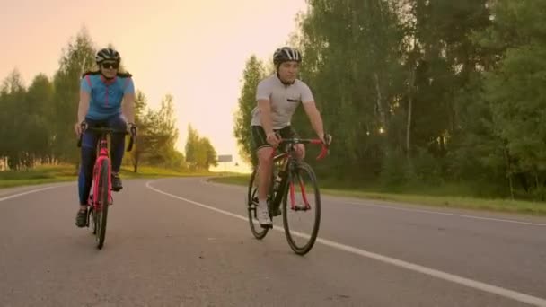 Empty Space. Sporty friends on bicycle on sunset. Couple cyclist go along coast. Sport in Nature background. Group of people two road biker in sunset — Stock Video