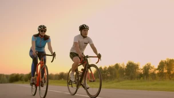 İki bisikletçi dağlarda birlikte biner. Sert antrenmanlar sırasında eğlenen spor takımından iki profesyonel bisikletçinin yumuşak odaklı el çekimi, sprint. — Stok video