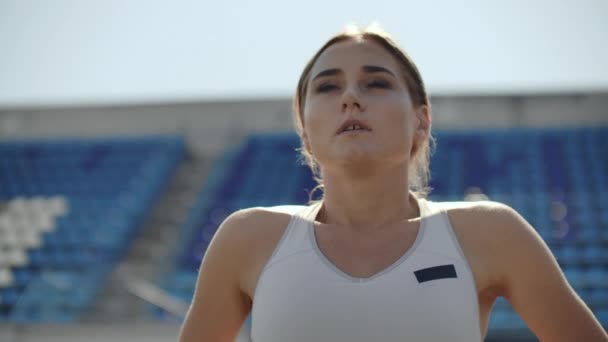Портрет красивої жінки, що бігає на стадіоні з концентрованим глибоким диханням і мотивує себе і свідомість для перегонів. Відкинути непотрібні емоції — стокове відео