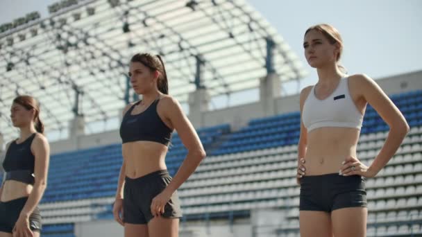 Corredores do sexo feminino no atletismo rastreiam agachamento nos blocos iniciais antes de uma corrida. Em câmara lenta — Vídeo de Stock