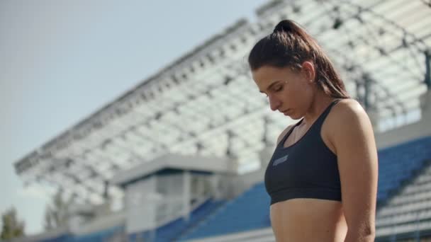 Slow motion: atlet kvinna väntar i Start blocket på löparbana. — Stockvideo