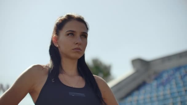 Bella atleta donna allo stadio respirando e preparandosi a iniziare la gara. Motivazione e sintonia per la gara. Concentrazione e atteggiamento . — Video Stock