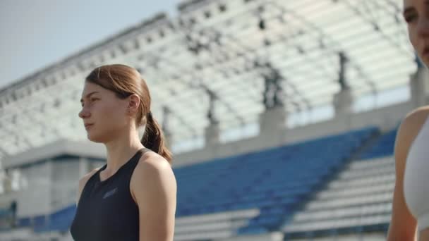 Vacker kvinna idrottare på arenan andas och förbereder sig för att starta loppet. Motivation och stämning för loppet. Koncentration och attityd. — Stockvideo