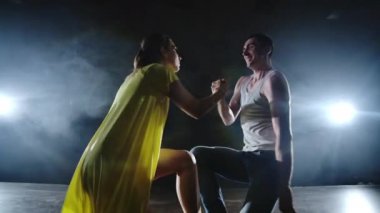 sahnede bir duman ve spot ışıkları dans eden dans eden bir çift