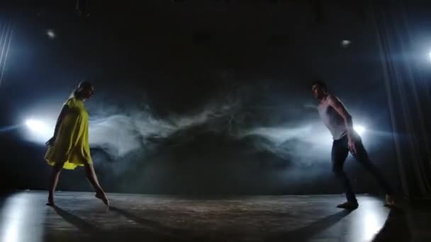 A couple of dancers on stage in smoke and spotlights — Stock Video