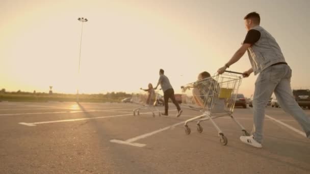 Jóvenes amigos divirtiéndose en carritos de compras. Jóvenes multiétnicos jugando con carrito de la compra . — Vídeo de stock