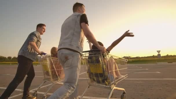 Mladí přátelé se baví na nákupních vozících. Multietnické mladé lidi hrající s nákupním košíkem. — Stock video