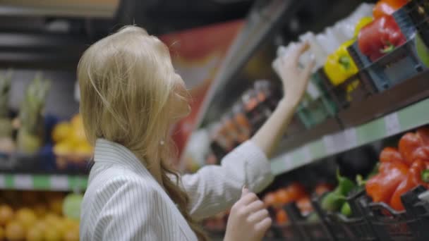 Frau kauft gelben Paprika im Supermarkt. Frauen nehmen und wählen Bio-Gemüse im Lebensmittelladen. Zero Waste Shopping und gesundes Lebensstil-Konzept. Zeitlupe — Stockvideo