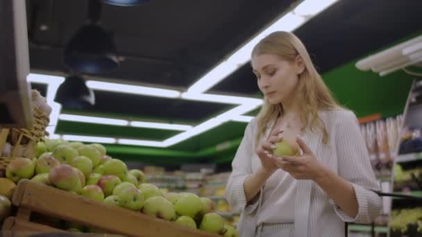 Mujer seleccionando manzanas rojas frescas en la venta de supermercados de comestibles, mercado de compras de alimentos tomando la elección de las manzanas chica con el bolso de compra de manzanas en la cesta de la compra — Vídeo de stock