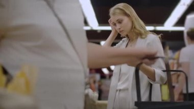 Çekici kız müşteri ekmek satın alma fırında, gülümseyerek ve arabası alışveriş koyarak kokulu salonu, bölümüdür. Sağlıklı yaşam tarzı ve süpermarket kavramı