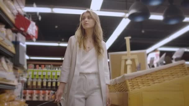 Sale, shopping, consumerism and people concept - happy young woman choosing and reading label on bread in market. — Stock Video