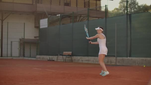 Juego de tenis en el día soleado en la cancha de tenis joven sportiv mujer jugando tenis profesional. Juego de tenis en el día soleado en la cancha de tenis joven mujer deportiva jugando — Vídeo de stock