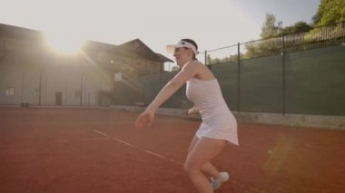 Profesyonel donanımlı kadın tenis raket ile tenis topu sert yenerek. Profesyonel donanımlı kadın tenis raket ile sert tenis topu yenerek.
