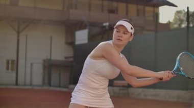 Profesyonel donanımlı kadın tenis raket ile tenis topu sert yenerek. Profesyonel donanımlı kadın tenis raket ile sert tenis topu yenerek.